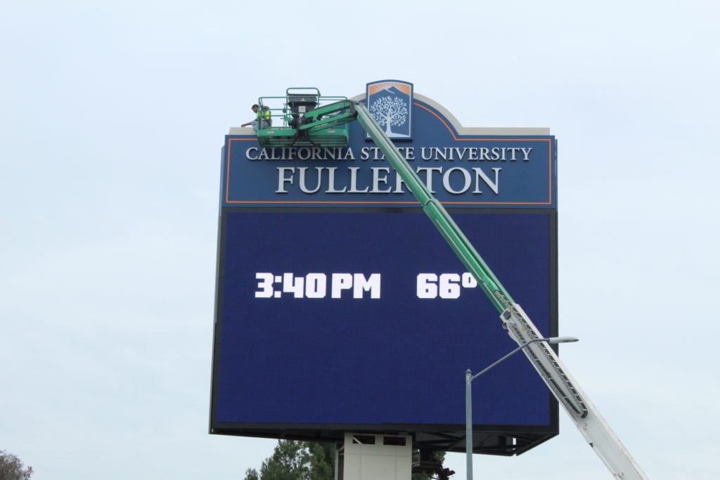 Encore Image team working on digital display sign for CSUF